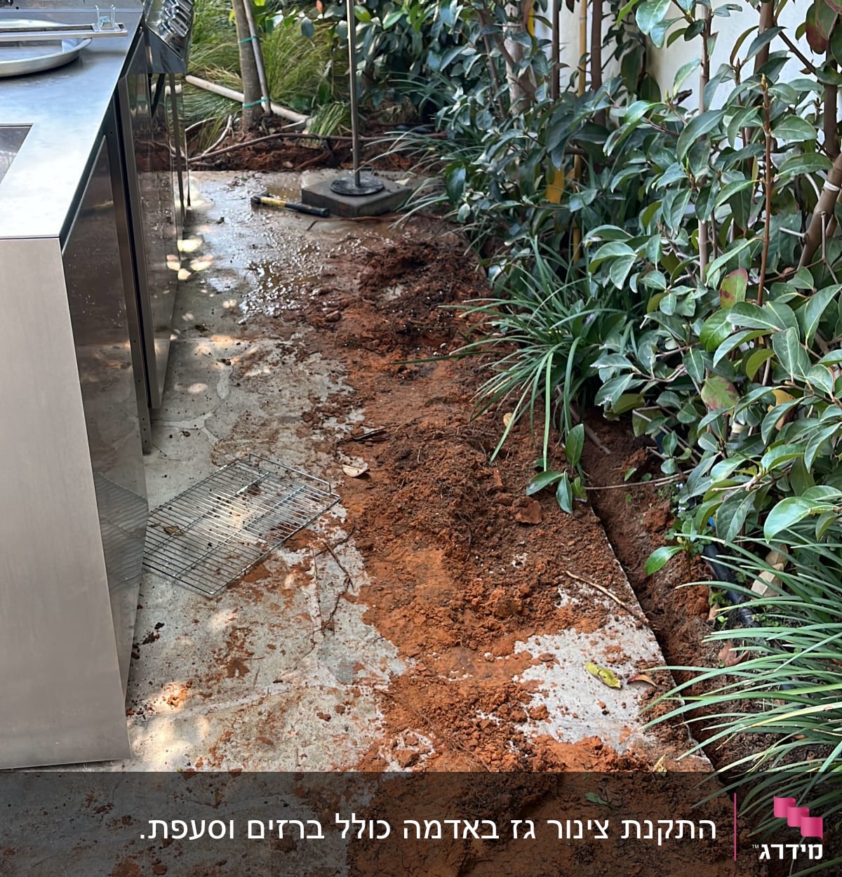 מנגל גז נירוסטה ליד שביל עם אדמה חשופה